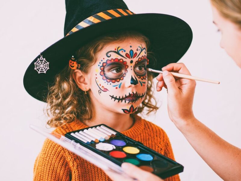 Kind wird für Halloween geschminkt