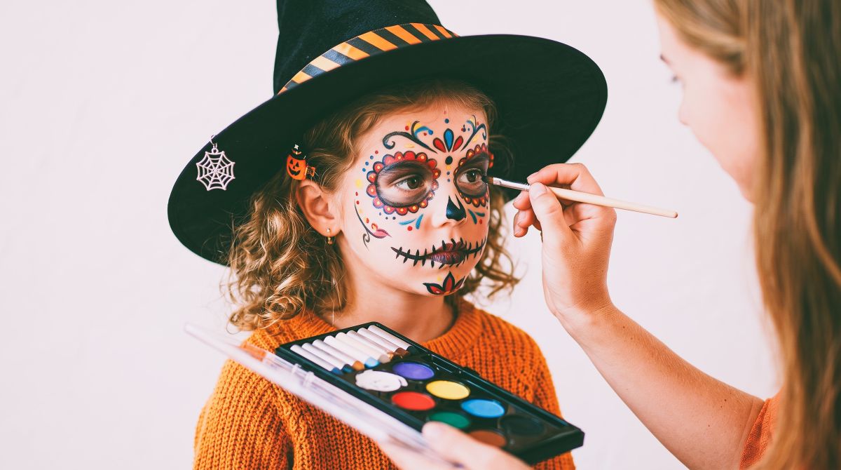 Kind wird für Halloween geschminkt
