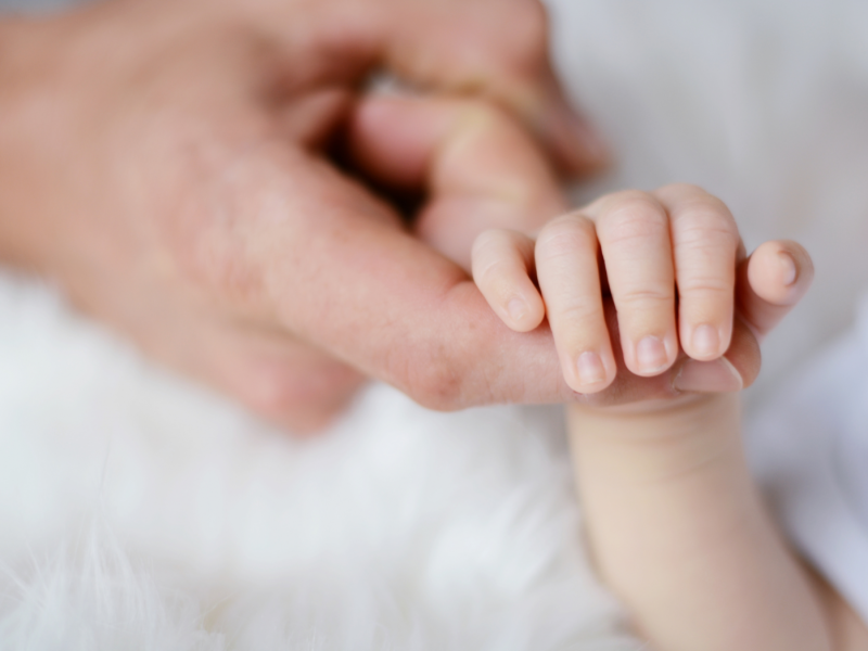 Eine Hand hält eine Babyhand