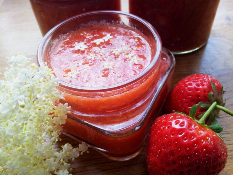 Erdbeermarmelade im Glas mit Holunderblüten