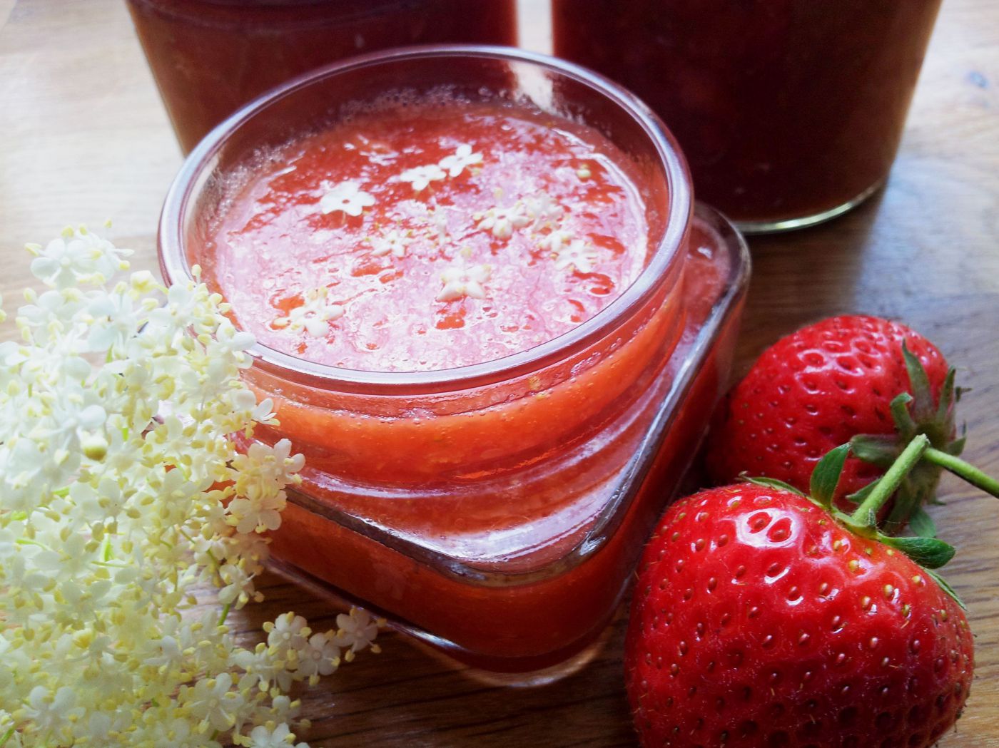 Erdbeermarmelade im Glas mit Holunderblüten