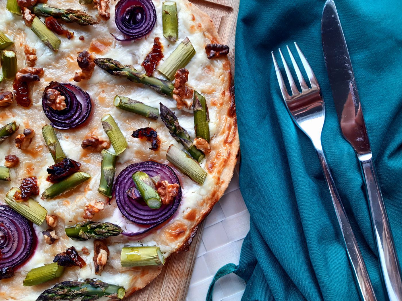 Flammkuchen mit Spargel auf einem Brett