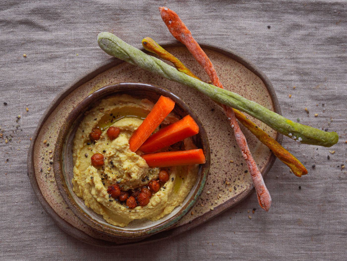 bunte Grissini serviert mit cremigem Hummus