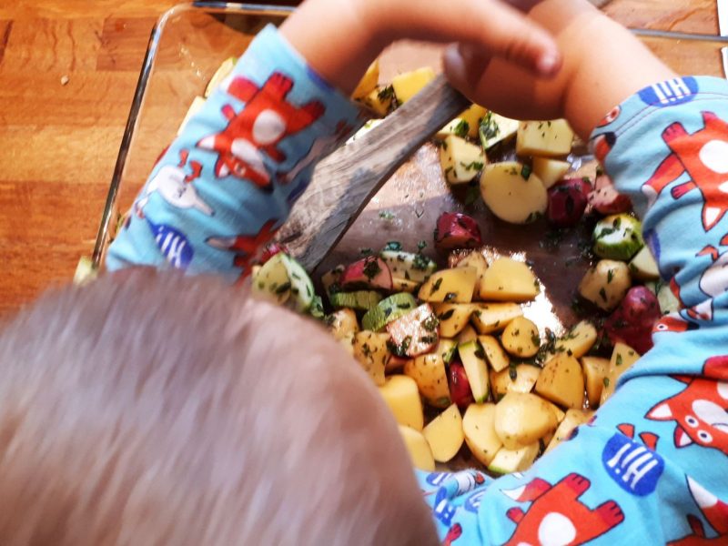 Kind kocht mit bunten Erdäpfeln
