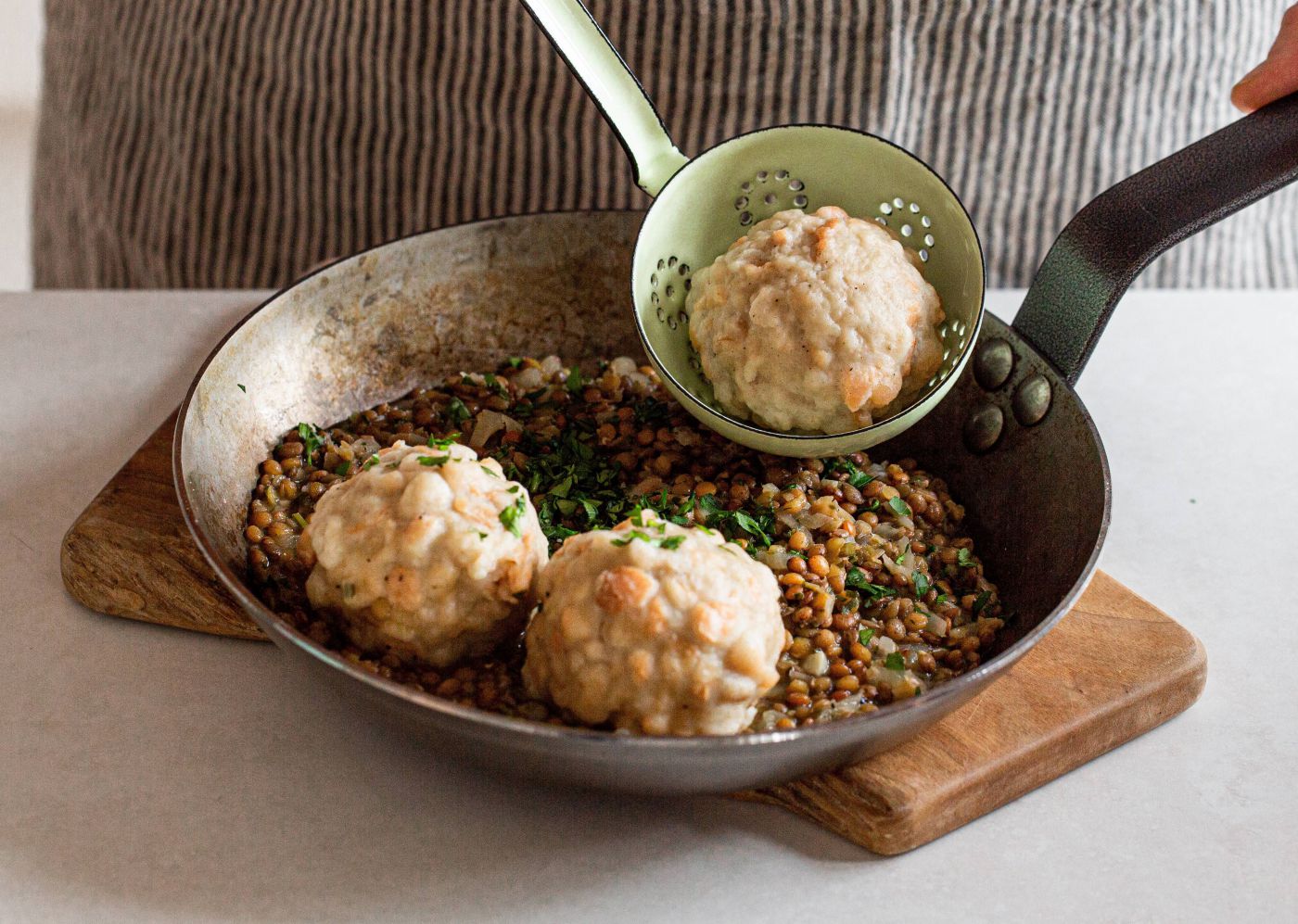 Pfanne mit drei Knödel und Linsen mit Petersilie