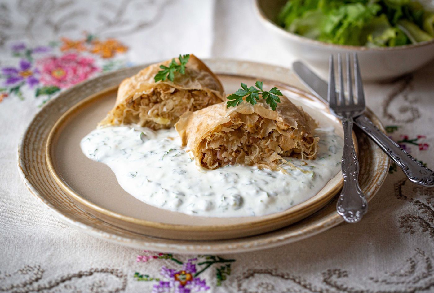 saftiger Krautstrudel, angerichtet am Teller mit Joghurtsoße