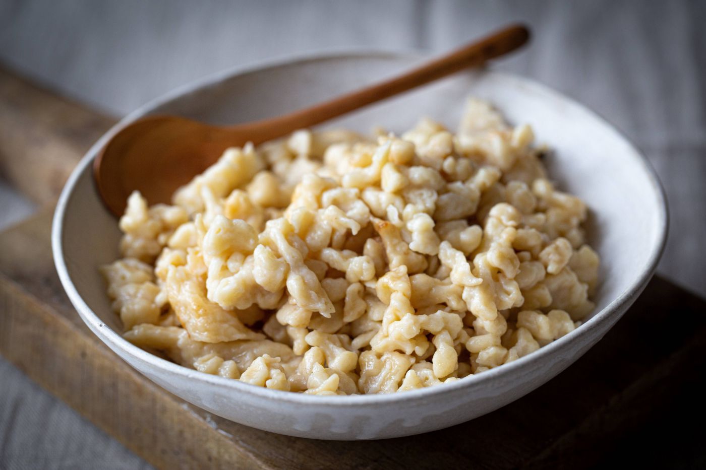 Frische Spätzle auf einem Teller mit Holzlöffel