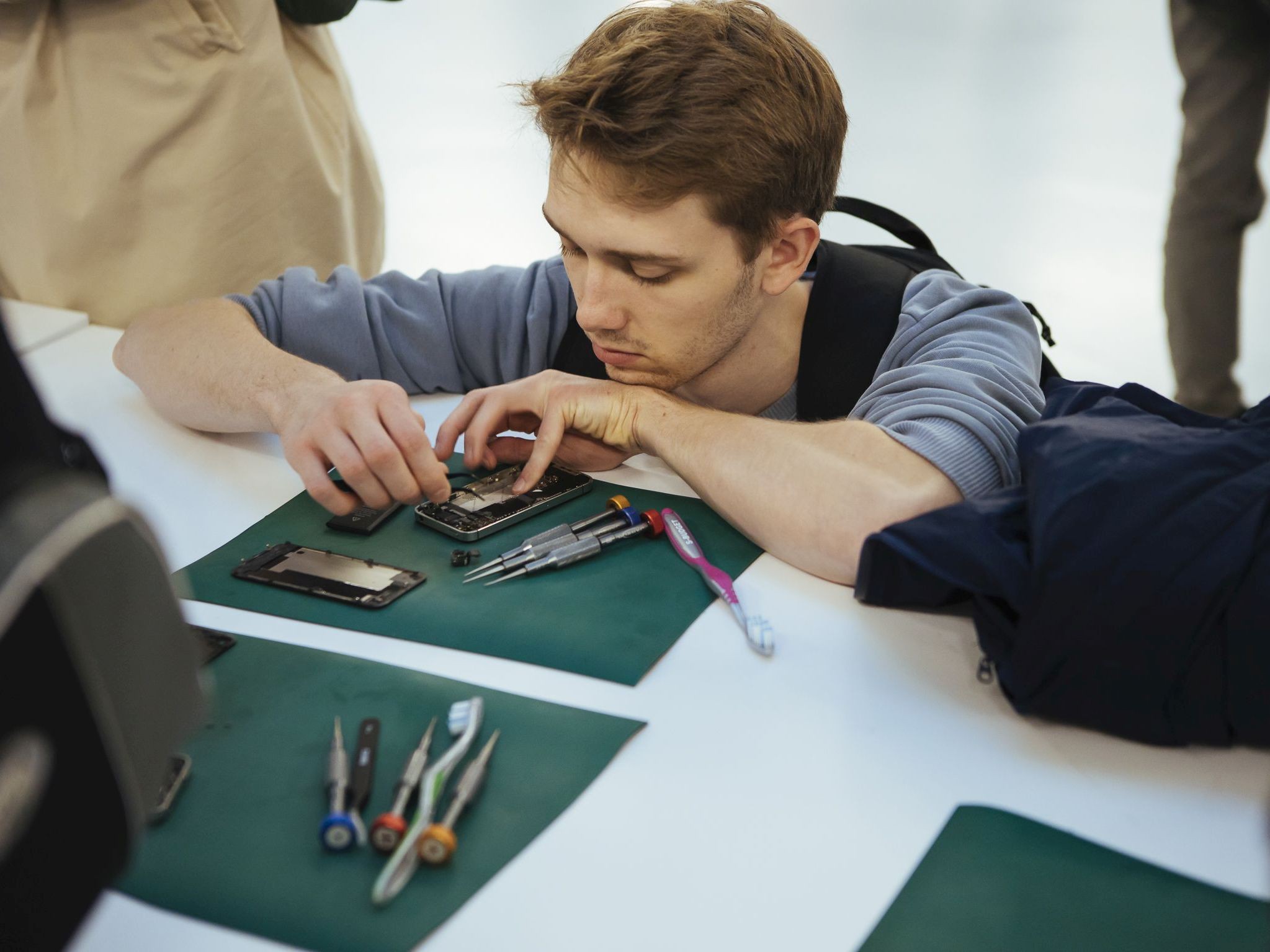Junger Mann repariert Handy