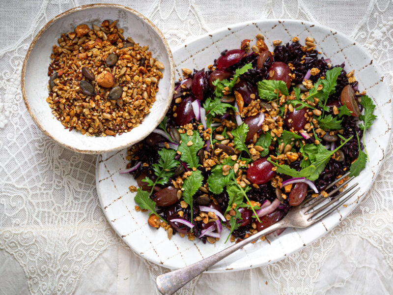 ein großer Teller gefüllt mit dem Salat aus schwarzen Reis, Ruccola, frischen Weintrauben und dem salzigen Granola