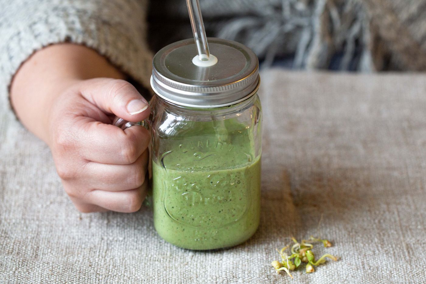 grüner Smoothie in einem Glas mit Strohhalm