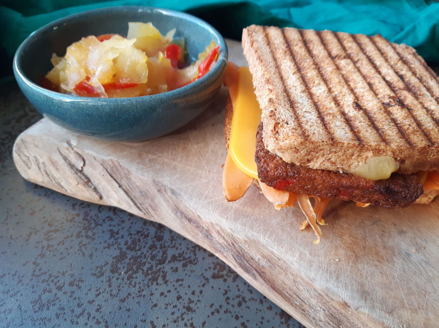 Holzbrett mit veganem Toast und Schüssel mit Krautsalat